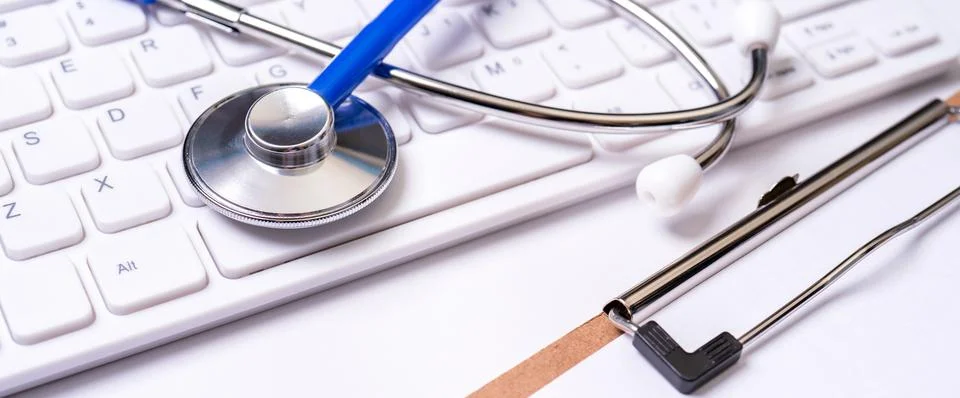 Stethoscope on computer keyboard on white background. Physician write medical Foto stock