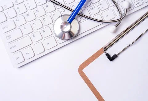 Stethoscope on computer keyboard on white background. Physician write medical Foto stock