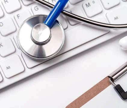 Stethoscope on computer keyboard on white background. Physician write medic.. Stock Photos