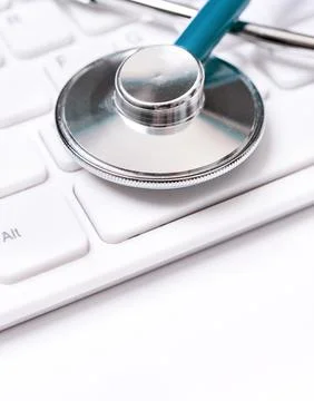 Stethoscope on computer keyboard on white background. Physician write medic.. Stock Photos