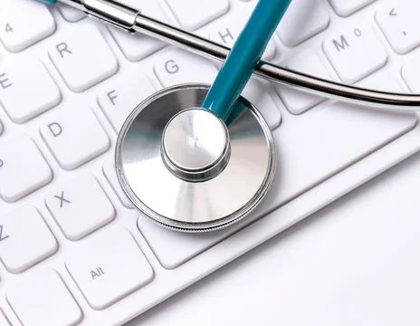 Stethoscope on computer keyboard on white background. Physician write medic.. Stock Photos