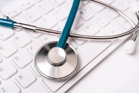 Stethoscope on computer keyboard on white background. Physician write medic.. Stock Photos