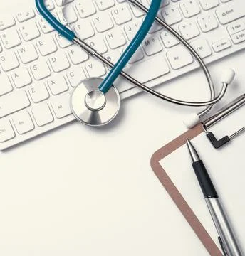 Stethoscope on computer keyboard on white background. Physician write medic.. Stock Photos