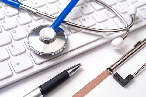 Stethoscope on computer keyboard on white background. Physician write medic.. Stock Photos