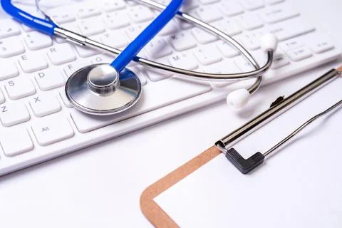 Stethoscope on computer keyboard on white background. Physician write medic.. Stock Photos