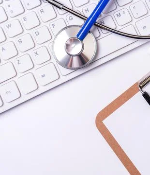 Stethoscope on computer keyboard on white background. Physician write medic.. Stock Photos