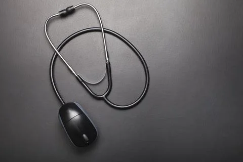 Stethoscope with computer mouse on dark background Photos