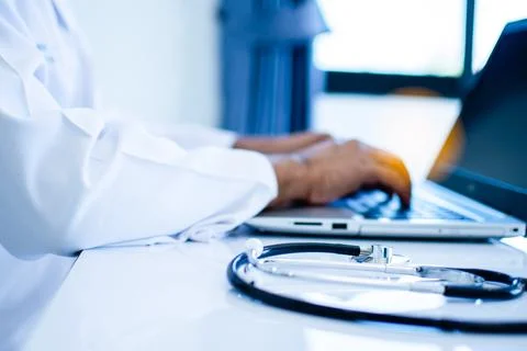 A stethoscope on a doctor's table using a laptop computer in a hospital lab Stock Photos
