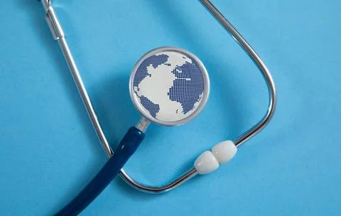 Stethoscope with a globe on the blue background. Stock Photos