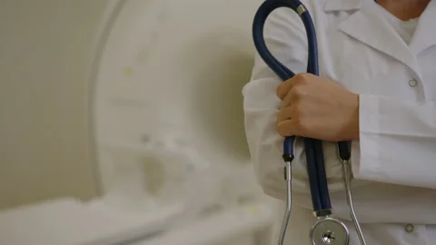 Stethoscope in the hands of an unrecognizable nurse on the background of an MRI Stock Footage 208000888