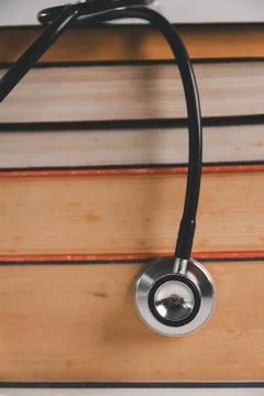 Stethoscope hanging over a stack of books, representing medical education, .. Stock Photos