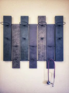 Stethoscope hanging from a wall mounted wine rack Stock Photos