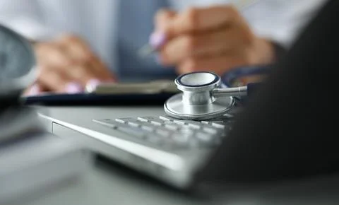 Stethoscope head lying on laptop computer keyboard Foto stock