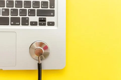 Stethoscope keyboard laptop computer isolated on yellow background. Modern Stock Photos