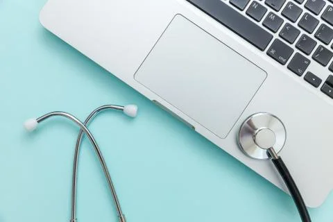 Stethoscope keyboard laptop computer isolated on blue background. Modern medi Stock Photos