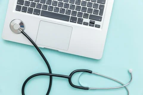 Stethoscope keyboard laptop computer isolated on blue background. Modern medi Stock Photos