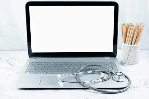Stethoscope on laptop and white screen on table.  Object for doctor Stock Photos