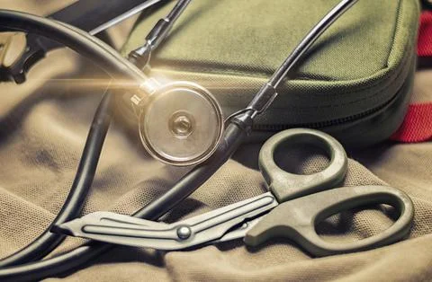 Stethoscope lies on a military uniform with scissors and a first-aid kit. T.. Stock Photos