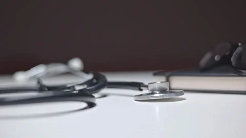 The stethoscope lies on the table under the passing light Stock Footage 244599336
