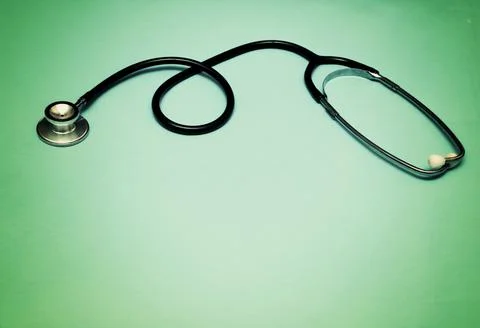 A stethoscope on a light green gradient background. Stock Photos