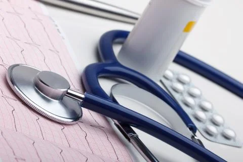 Stethoscope lying on red grid cardiogram Stock Photos