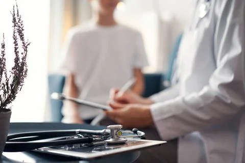 Stethoscope lying on the tablet computer in front of doctor and kid boy patient Stockfoto's