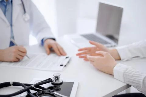 Stethoscope lying on the tablet computer in front of a doctor and patient Stockfoto's