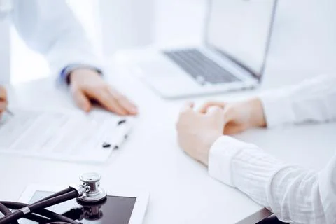 Stethoscope lying on the tablet computer in front of a doctor and patient Stockfoto's