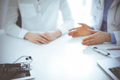 Stethoscope lying on the tablet computer in front of a doctor and patient Stockfoto's