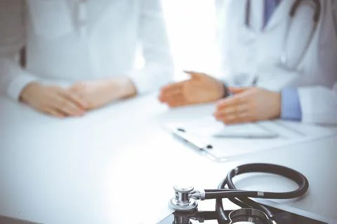 Stethoscope lying on the tablet computer in front of a doctor and patient Foto stock