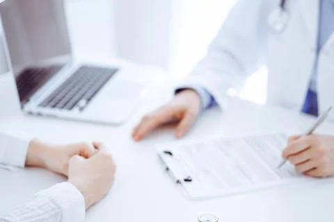 Stethoscope lying on the tablet computer in front of a doctor and patient Stockfoto's