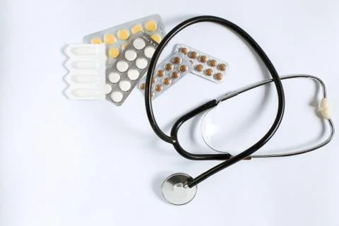 Stethoscope, multi-colored tablets and vitamins in plates Stock Photos