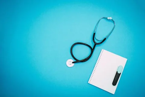 Stethoscope, notepad and marker on a light blue background Stock Photos