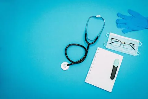 Stethoscope, notepad, marker, glasses, disposable gloves and a medical mask o Stock Photos