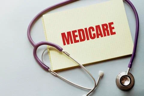 Stethoscope, pens and note with text MEDICARE on the white background Stock Photos
