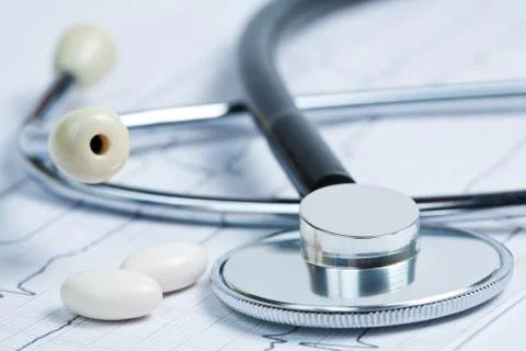 Stethoscope with pills on electrocardiogram Stock Photos