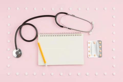 Stethoscope on a pink table. Stock Photos