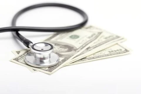 Stethoscope placed on banknotes on a white background. Stock Photos