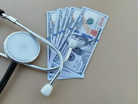 Stethoscope on a sheet of US Dollar 100 bills Stock Photos