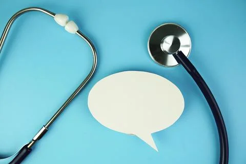 Stethoscope with speech bubble top view on blue background, health and busi.. Stock Photos