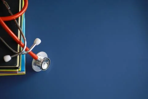 Stethoscope on stack of medical guide book for doctor learning treatment at.. Stock Photos