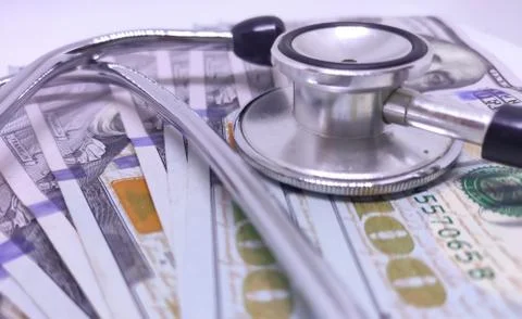 Stethoscope on US dollar bill. The concept of paid medicine. Medical cost. Stock Photos