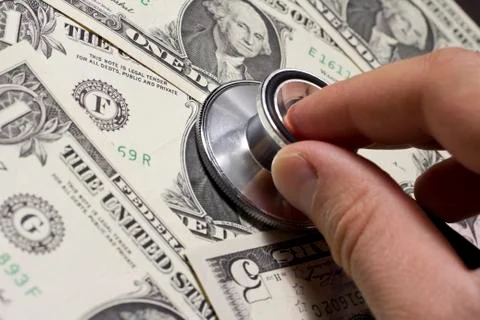 Stethoscope on various US dollar banknotes Stock Photos