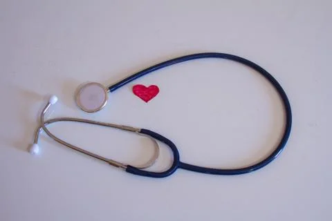 Stethoscope on a white background which is covered with one small hearts col Stock Photos