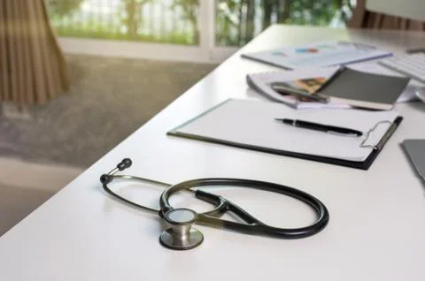 Stethoscope on the workplace table with some part of computer set and keyword Stock Photos