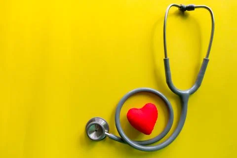 Stethoscope on a yellow background with space for text. Stock Photos