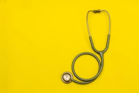 Stethoscope on a yellow background with space for text. Stock Photos