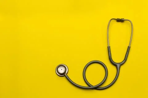 Stethoscope on a yellow background with space for text. Stock Photos