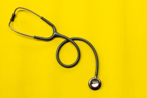 Stethoscope on a yellow background with space for text. Stock Photos