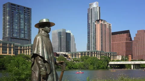 Stevie Ray Vaughan Statue in Front of Downtown Austin, Texas &amp; Colorado River Stock Footage 63020174